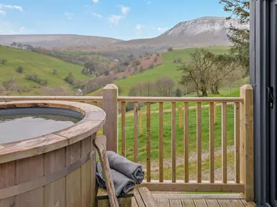 a hot tub on a deck with a view of mountains at 3 Bed in Brecon oc-94434 in Velindre
