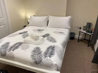 a bed with a black and white bedspread with a hat on it at Prince of wales pub and accommodation in Llangollen