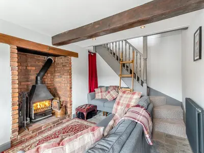 a living room with a couch and a fireplace at Dee Bank Cottage in Llangollen