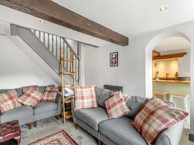 a living room with two couches and a staircase at Dee Bank Cottage in Llangollen