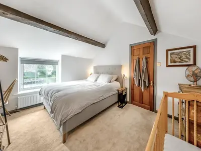 a bedroom with a bed and a wooden door at Dee Bank Cottage in Llangollen