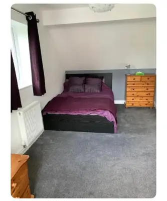 a bedroom with a bed with purple sheets and a dresser at The Little House, Oswestry in Oswestry