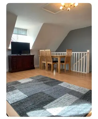 a dining room with a table and chairs and a television at The Little House, Oswestry in Oswestry