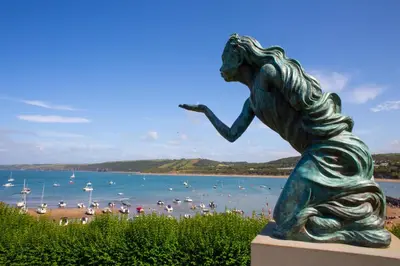 a statue of a woman sitting next to a beach at 3 Prospect Place New Quay in New Quay