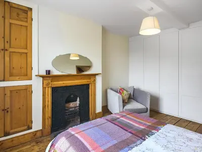 a bedroom with a fireplace and a bed and a chair at The Haven in Ludlow