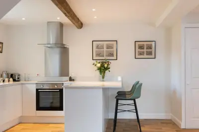 a kitchen with a counter with a vase of flowers on it at The Hop Kiln in Leominster