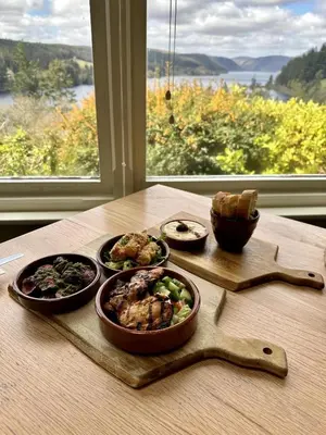 a table with plates of food on a table with a window at 1 Bed in Llanfyllin oc-p29023 in Llanfyllin