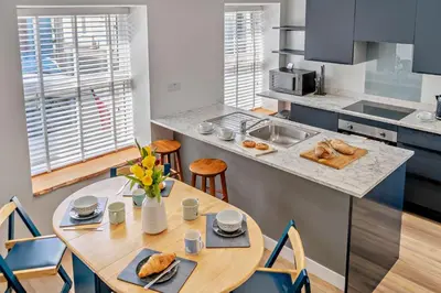 a kitchen with a wooden table and a kitchen with blue cabinets at 2 Bed in Aberaeron oc-t29116 in Aberaeron