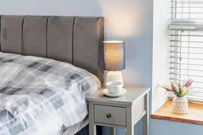 a bed with a table with a lamp on it at 2 Bed in Aberaeron oc-t29116 in Aberaeron
