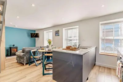 a kitchen and living room with a table and a couch at 2 Bed in Aberaeron oc-t29116 in Aberaeron