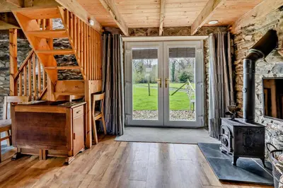 a living room with a wood stove and a staircase at 2 Bed in Cross Inn oc-t29117 in Cross Inn