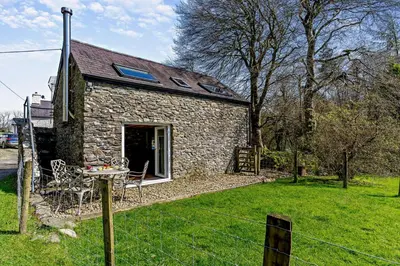 a stone house with a table and chairs in a yard at 2 Bed in Cross Inn oc-t29117 in Cross Inn