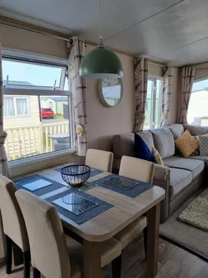 a living room with a table and a couch at Bayview at Pengarreg in Llanrhystyd