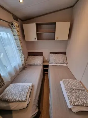 two beds in a small room with a window at Bayview at Pengarreg in Llanrhystyd