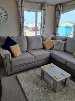 a living room with a couch and a coffee table at Bayview at Pengarreg in Llanrhystyd