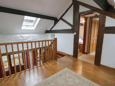 a room with a staircase and wooden beams at Graig Las The Barn in Oswestry