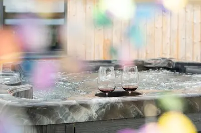 two glasses of wine sitting in a hot tub at Cae Dafadd in Newtown