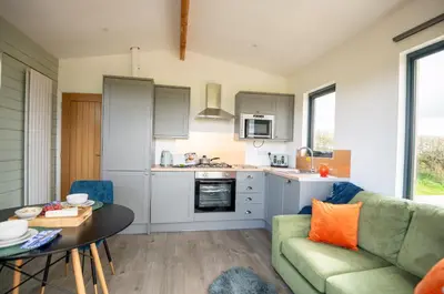 a kitchen and living room with a couch and a table at Cae Pren in Newtown