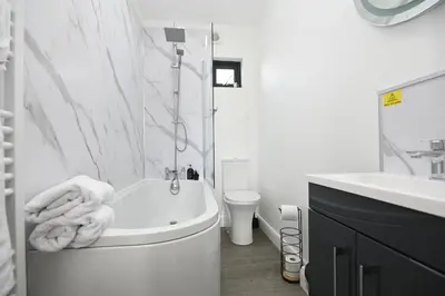 a white bathroom with a tub and a sink at Cae Pren in Newtown