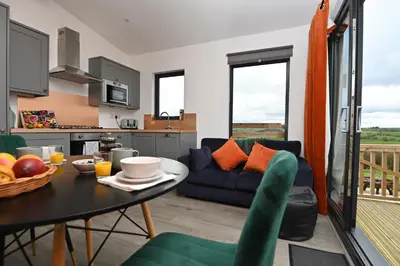 a living room with a blue couch and a table at Cae Bedw in Newtown