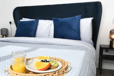 a tray of fruit and juice on a bed at Cae Bedw in Newtown