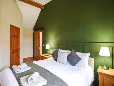 a green bedroom with a bed with towels on it at Uk46555 - Ragleth in Church Stretton