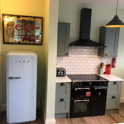 a kitchen with a stove and a refrigerator at Llangollen Townhouse 4 bedroom in Llangollen