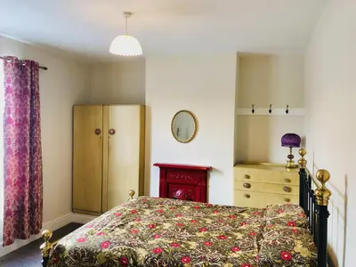 a bedroom with a bed and a dresser at Llangollen Townhouse 4 bedroom in Llangollen