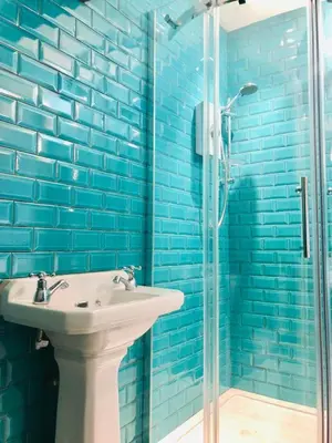 a bathroom with a sink and a glass shower at Llangollen Townhouse 4 bedroom in Llangollen