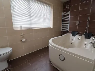 a bathroom with a white tub and a toilet at Llangollen in Llangollen