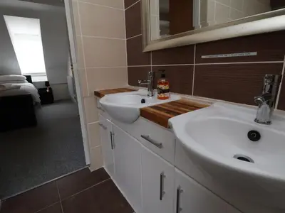 a bathroom with a white sink and a mirror at Llangollen in Llangollen