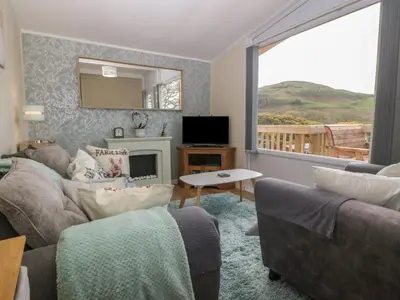 a living room with a couch and a tv at Y Goedlan in Tywyn