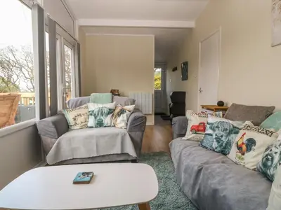 a living room with two couches and a window at Y Goedlan in Tywyn
