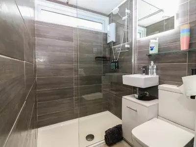 a bathroom with a shower and a toilet and a sink at Y Goedlan in Tywyn