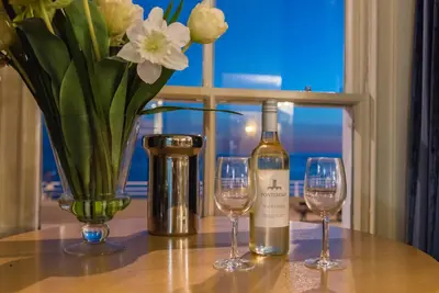 a table with a bottle of wine and two glasses at Marine Apartment in Aberystwyth