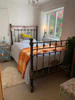 a bedroom with a bed with an orange and white comforter at Tamarisk in Clyro