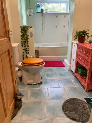 a bathroom with a toilet and a tub with a window at Tamarisk in Clyro