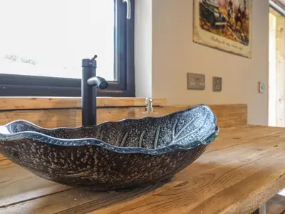 a bowl shaped sink sitting on a wooden table at Bwncath in Welshpool