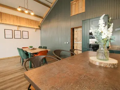 a room with a table with chairs and a vase of flowers at Bwncath in Welshpool