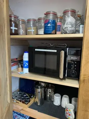 a kitchen shelf with a microwave and other kitchen items at Mountain views in the heart of Brecon Town in Brecon