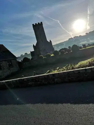 a building on the side of a road with the sun at Quirky Cottage with Private Garden Nr New Quay Cardigan Bay in Llandysul
