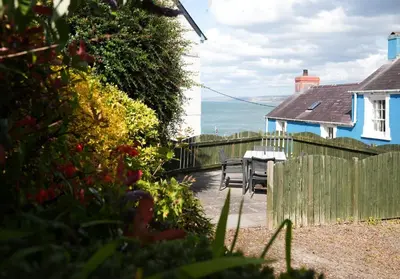 a patio with a table and chairs and a house at 3 Prospect Place, New Quay, sleeps 6, parking, sea views, dog friendly in New Quay