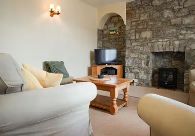 a living room with a couch and a fireplace at 3 Prospect Place, New Quay, sleeps 6, parking, sea views, dog friendly in New Quay