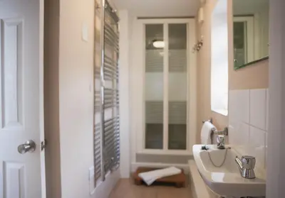 a white bathroom with a sink and a mirror at 3 Prospect Place, New Quay, sleeps 6, parking, sea views, dog friendly in New Quay
