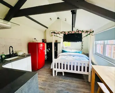 a kitchen with a red refrigerator and a bed in a room at Tiny Romantic Retreat with Hot Tub on a Country Estate near Cardigan Bay in Eryri Snowdonia in Llanbedr