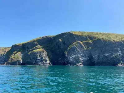 a view of a mountain from the water at Cottage in the Countryside Near New Quay West Wales in Llandysul