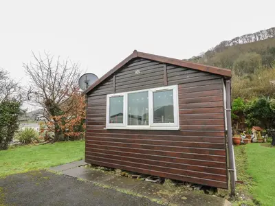 a small house with a window in a yard at Chalet 32 in Aberystwyth