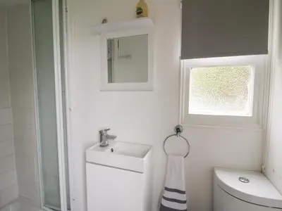 a bathroom with a sink and a toilet and a window at Chalet 32 in Aberystwyth