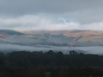 a foggy valley with hills and trees in the foreground at Stunning views of Ynyshir & Southern Snowdonia in Machynlleth