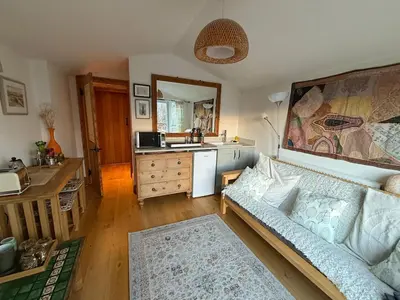 a living room with a couch and a kitchen at Stunning views of Ynyshir & Southern Snowdonia in Machynlleth